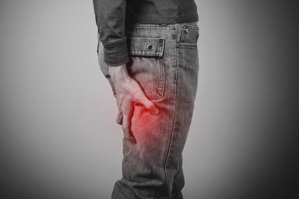 Man holding hip in pain